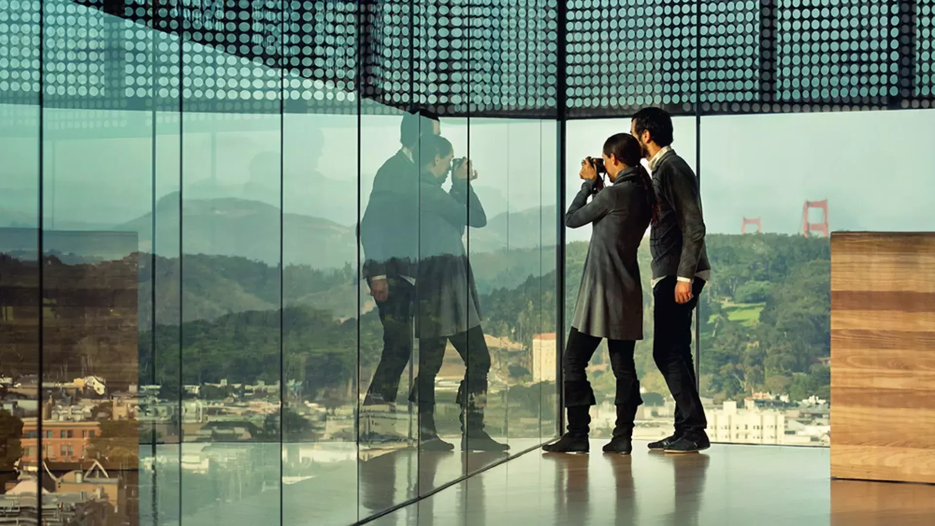 两个人透过玻璃墙看贝博体彩app德扬博物馆.