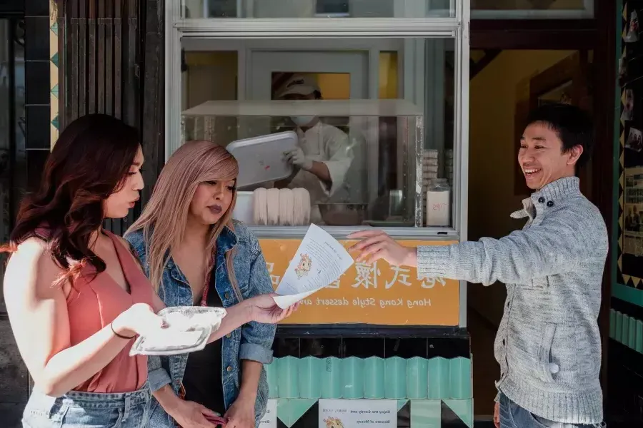 那克鲁兹 and friend looking at a menu in 唐人街