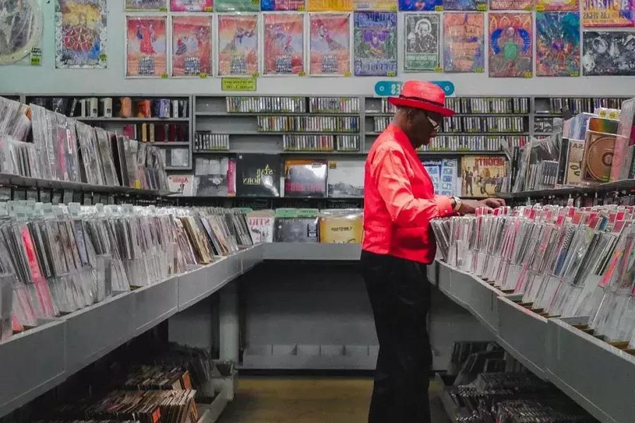 Un homme en veste rouge achète des disques chez Amoeba Records 在贝博体彩app.