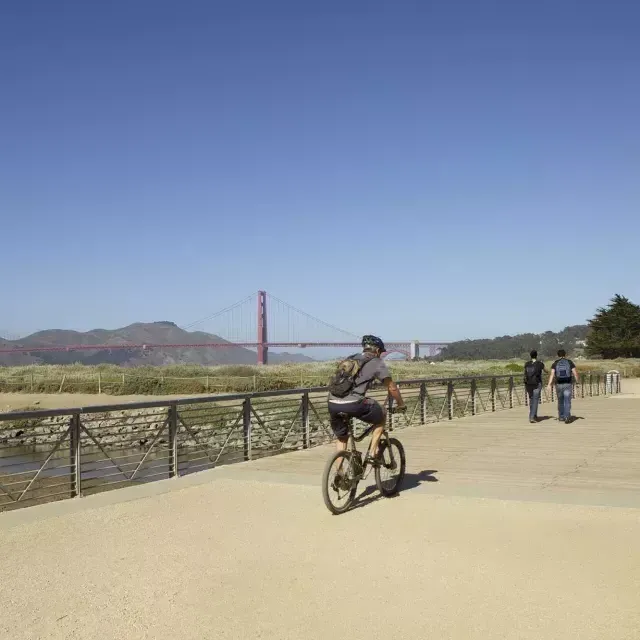 Ein Mann fährt mit dem Fahrrad einen Wanderweg am Crissy Field entlang. San Francisco, Kalifornien.