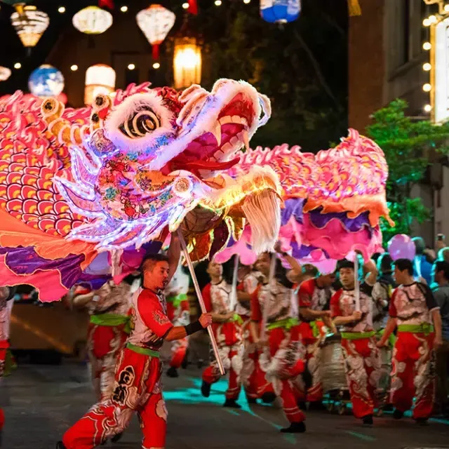 Tänzer manipulieren während der Lunar New Year Parade in San Francisco einen riesigen, beleuchteten Drachen.